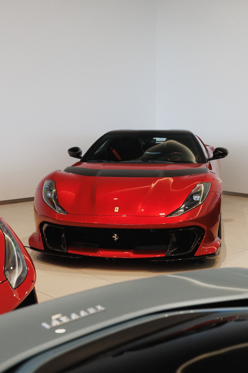 A shiny red sports car with a black roof
